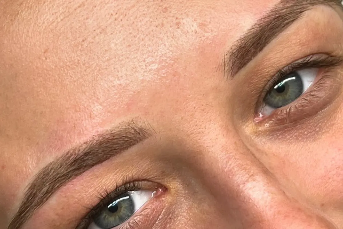 Healed powder brows on a client, softly shaded and following her natural brow shape.